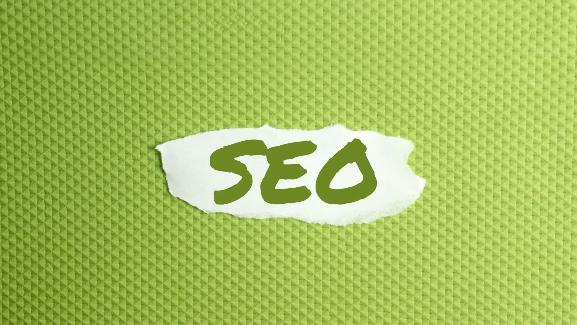 a torn paper written with inscription SEO on a green background
